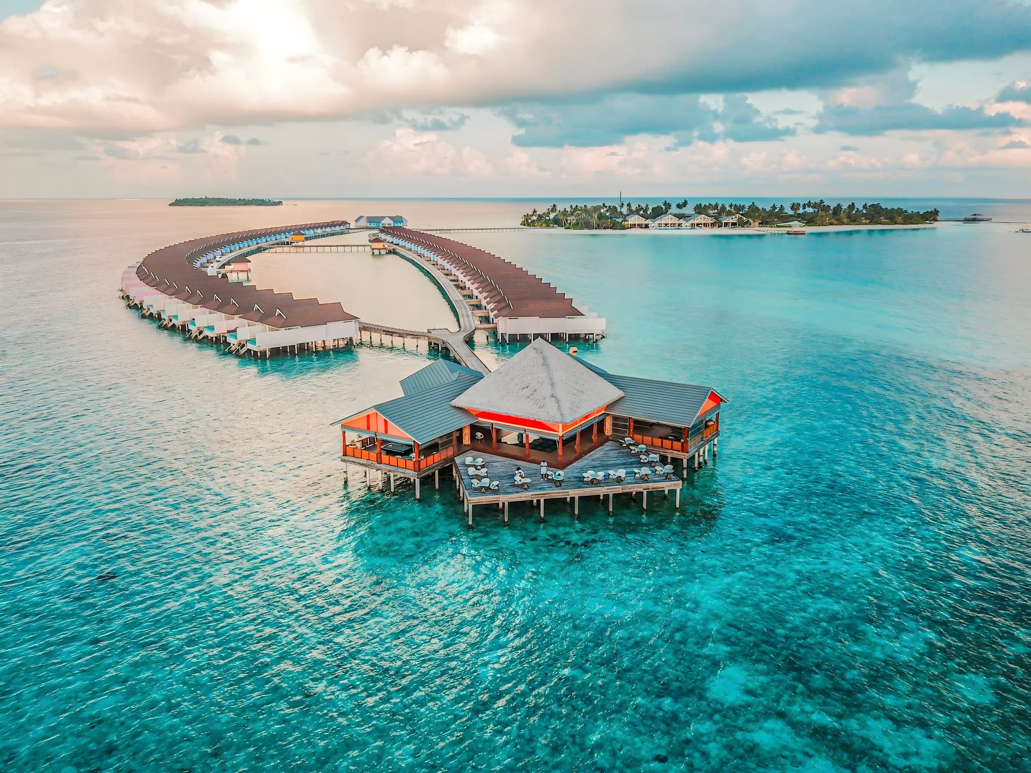 Aerial view of overwater villas ringing a Maldivian lagoon